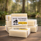 Stack of Bayou Backwoods Honey Oats soap bars with a natural bayou background. Shop small business 